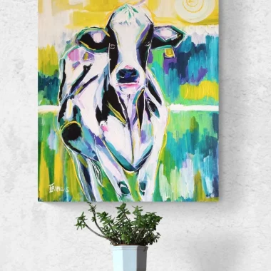 ציור מקורי: הקובץ il_fullxfull.6240121042_762l.jpg מציג פרה צבעונית בסגנון פופ ארט בכחול, סגול, צהוב וירוק, המוצגת על קיר לבן מרקם מעל מדף עץ עם עציץ קטן של צמח סוקולנט. מוסיף צבע וייחודיות לכל חלל.