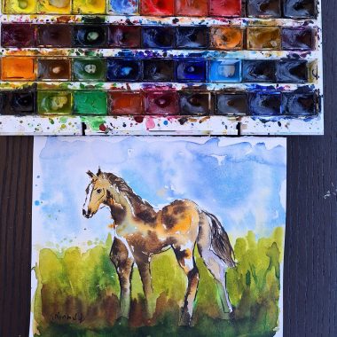 ציור מקורי: הקובץ il_fullxfull.6425680453_j5vn.jpg מציג ציור בצבעי מים של סוס חום ולבן על דשא ירוק תחת שמיים כחולים, עם פלטת צבעים משומשת מעל — יצירת אמנות ייחודית לסוסים המתאימה לכל חדר. מוסיף צבע וייחודיות לכל חלל.