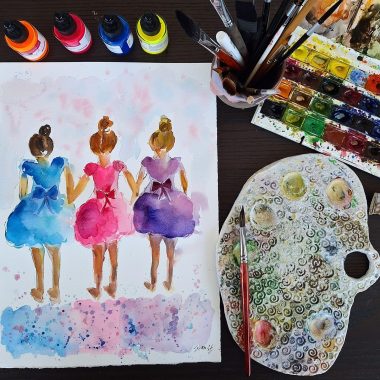 ציור מקורי: הקובץ il_fullxfull.6608389329_g2wd.jpg מציג שלוש בלרינות חמודות בשמלות צבעוניות, נראות מאחור, מוקפות במכחולים, בקבוקי דיו, צבעי מים ופלטה מוכתמת בצבע על שולחן כהה. מוסיף צבע וייחודיות לכל חלל.